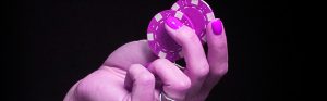 woman's hand holding poker chips