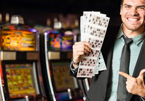 man holding and pointing at cards from slot machine