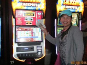 Woman holding money and sitting in front of slot machine